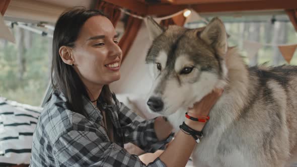 Happy Woman Petting Husky in Camper