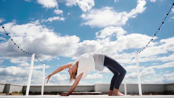 Young Woman Doing Yoga Stretching Chakrasana Wheel Pose in Slow Motion