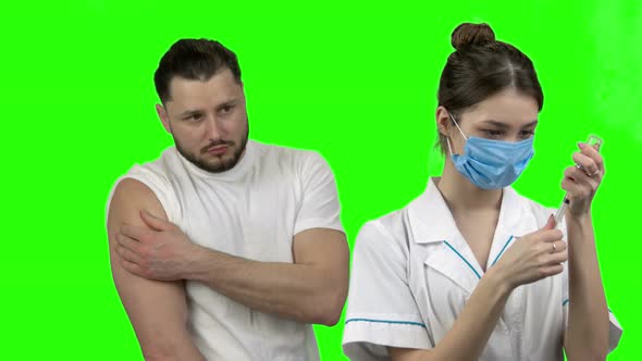 Young Woman Doctor Vaccinating a Man From Virus