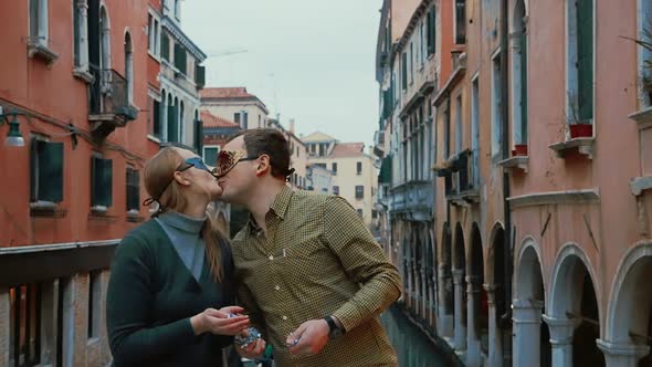 Couple in Venetian Masks Throwing Confetti