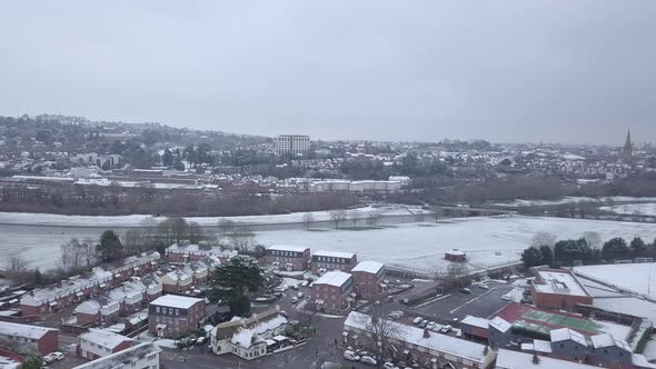 Panning drone shot of snowy Exeter over the River Exe