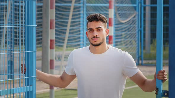 Portrait of Brooding Serious Millennial Middle Eastern Indian Guy Standing Posing in Stadium After