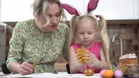 Mom and Daughter Paint Chicken Eggs at Home for the Traditional Christian Holiday Easter