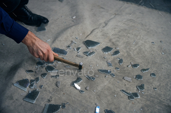 Man breaks triplex glass with a hammer