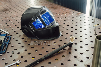 Kit of used welding equipment. Welding mask with welding machine, protective gloves, and arc steel