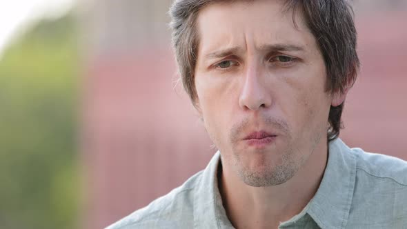 Closeup of Young Caucasian Guy in Shirt Biting Off Apple with Smile Feels Sudden Sharp Pain Touches