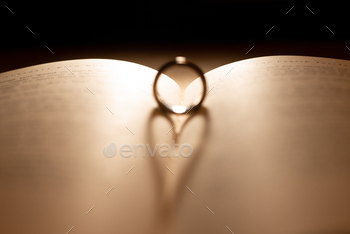 Wedding ring on the pages of a book in a heart shape