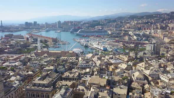 Aerial panoramic drone view of buildings and streets surrounding Port of Genoa.Cruise ship in port.