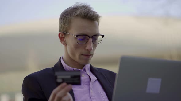 Serious Young Blond Man Making Online Purchases