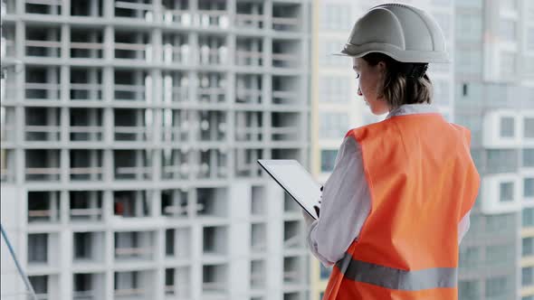 Engineer working at Construction Site. A woman with a tablet at a construction site