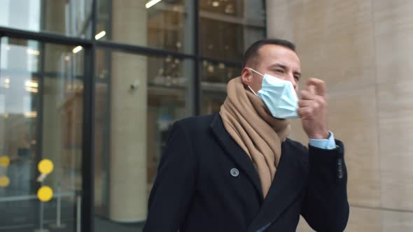 Happy Businessman Leaving Office Building and Taking Off Protective Mask