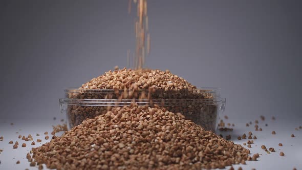 Buckwheat Is Poured Into a Storage Jar, Close-up, Slow-motion. Buckwheat Stocks During the Period of