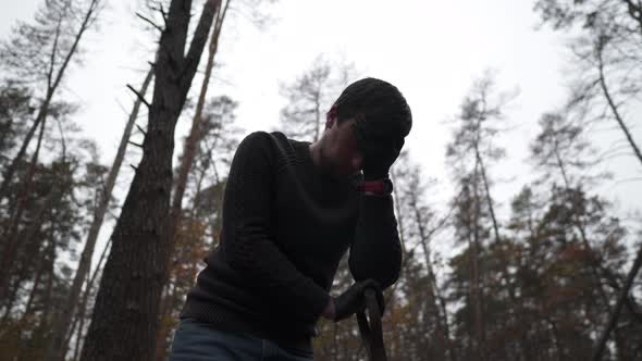 A Grieving Man Stands at the Grave with a Shovel and is Very Sad About the Funeral