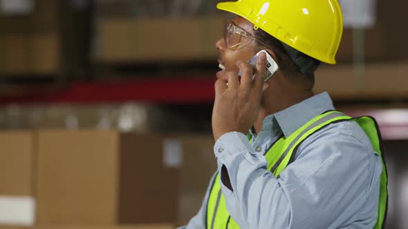 Industry worker using cell phone in shipping warehouse