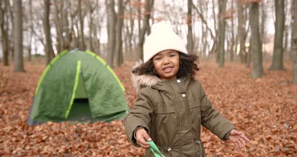 Mixed Race Girl Staying Near Camp in Autumn Forest