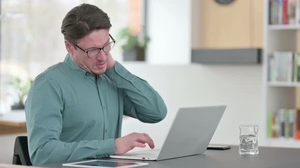 Middle Aged Man Having Neck Pain While Working on Laptop
