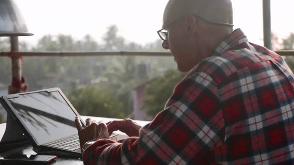 Handsome Man Typing on Laptop Outdoor