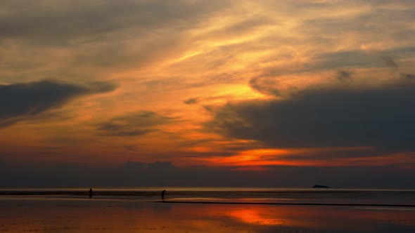 Asian Fishermen Walking on the Beach at Low Tide Silhouette of Two People at Sunset