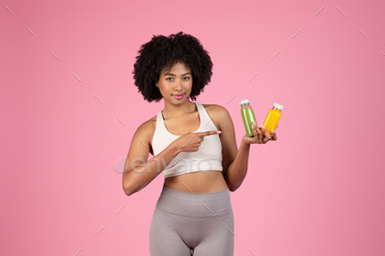 Healthy black woman recommending green and yellow juices