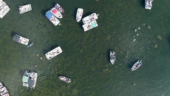 Aerial top down, spring break party boats crowded on a lake during summer holiday