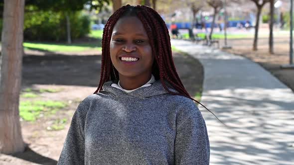 A Young Black Woman Walks Down the Path and Starts Laughing