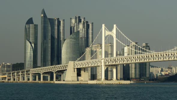 Busan, South Korea. Pannnig Shot of GwangAn Bridge and Skyscrapers in City Center of Busan