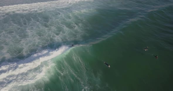 Aerial overhead view with surfers and wave in ocean in the Portugal coast, Cascais, Guincho