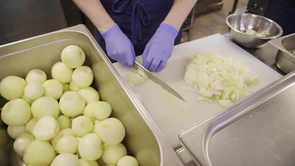 Restaurant Cook Chef Cutting Onions on a Board Top View