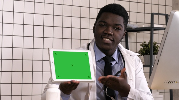 Friendly doctor presenting digital tablet screen. Green