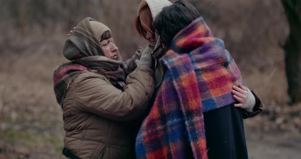 Female Homeless Refugees Consoling And Praying Together