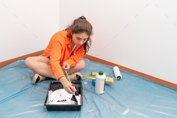 Woman preparing paint and tools to paint at home