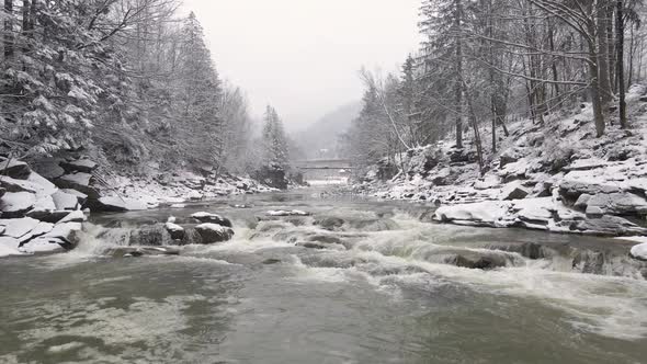 Close Up Aerial Drone View Over a Waterfall and Rocky Frozen River