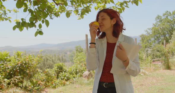 Girl in white coat sniffs yellow lemon