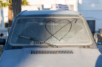 Dirty car window with drawn heart
