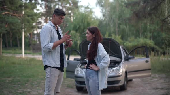 Side View Couple Talking Standing in Subsurb at Broken Automobile with Open Car Hood