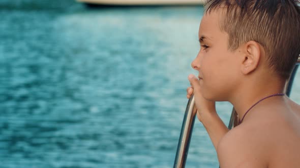 Child Looking Far Into Sea From Yacht During Cruise