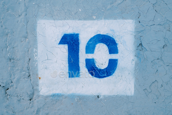 Number ten drawn in a white rectangle on a blue wall