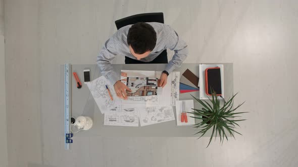 Engineer with Blueprints of Object and Laptop. Top View