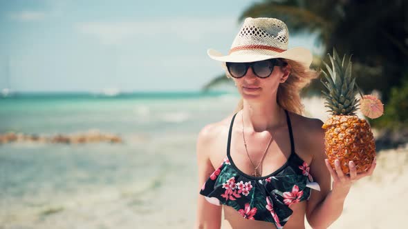 Woman In Swimsuit And Hat Walks Along Beach On Tropical Caribbean Coast. Girl In Bikini Walking.