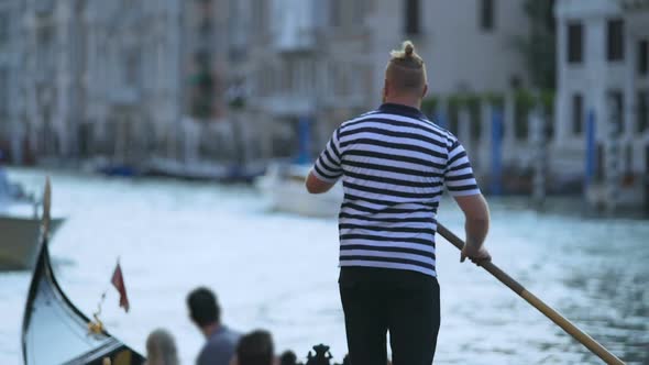 Stylish Venetian Boatman Propelling Gondola with Foreign Tourists, Earning Money