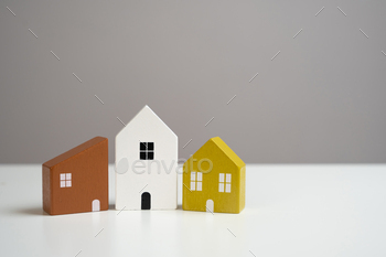 House figurines on a gray background. Buying and selling.