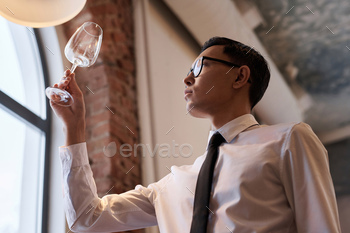 Restaurant Worker Checking Cleanliness Of Wine Glass