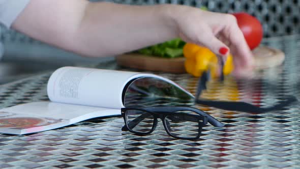 Glasses for Vision Lie on the Kitchen Table Next To Vegetables and a Magazine