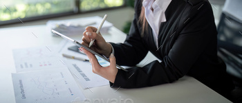 Businesswoman in office using tablet computer, audit documents and financial analysis, business