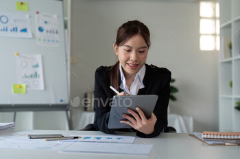 Businesswoman in office using tablet computer, audit documents and financial analysis, business