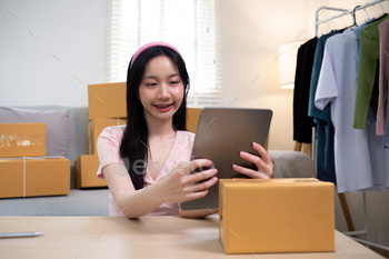 Woman asian in an online store check the customer address and package information on the laptop