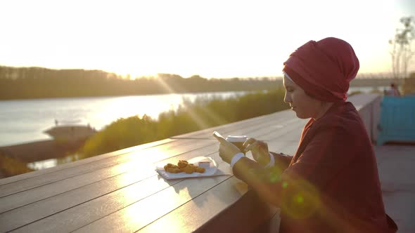 Young Muslim Woman Wearing Hijab Having Coffee Break Outdoor on City Background