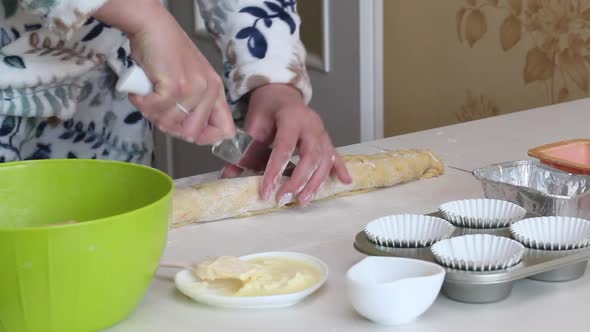 A Woman Cuts A Roll Of Rolled Dough. Prepares Cruffin With Raisins And Candied Fruit
