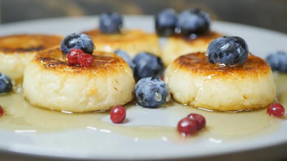 Curd Syrniki Cooked with Honey and Wild Berries in a Bowl