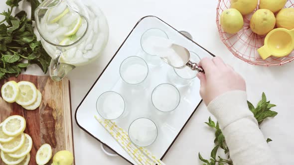 Step by step. Time lapse. Pouring traditional lemonade with fresh sliced lemons and mint into the gl